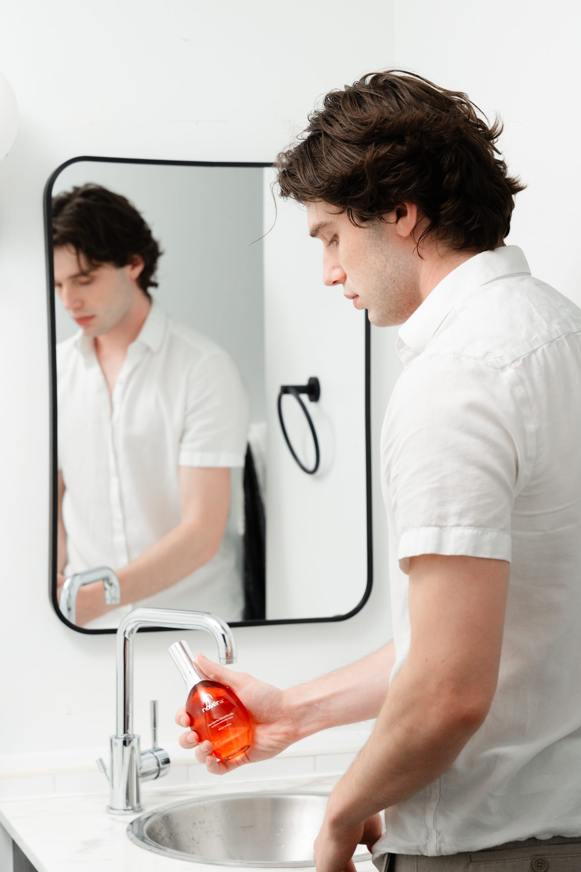 Man at bathroom mirror with Novéra Clear Quartz Face Mist